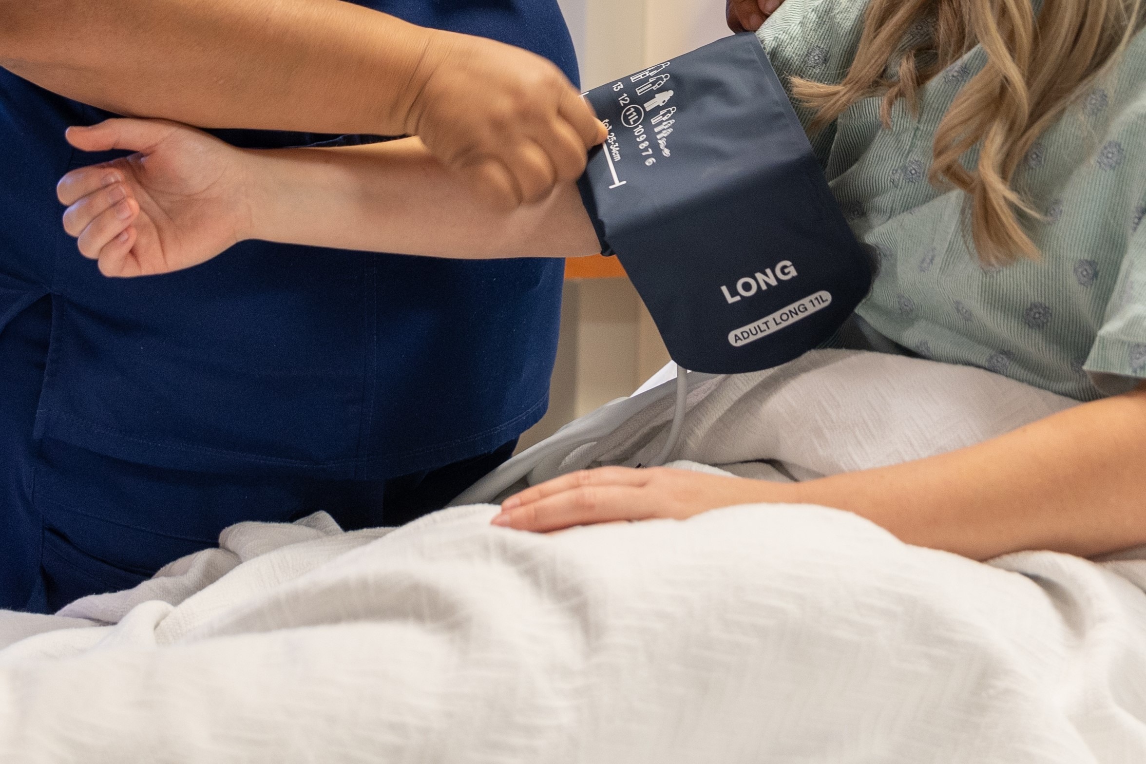 A Fisher-Titus nurse wraps a blood pressure cuff around a patient's arm to check for high blood pressure.